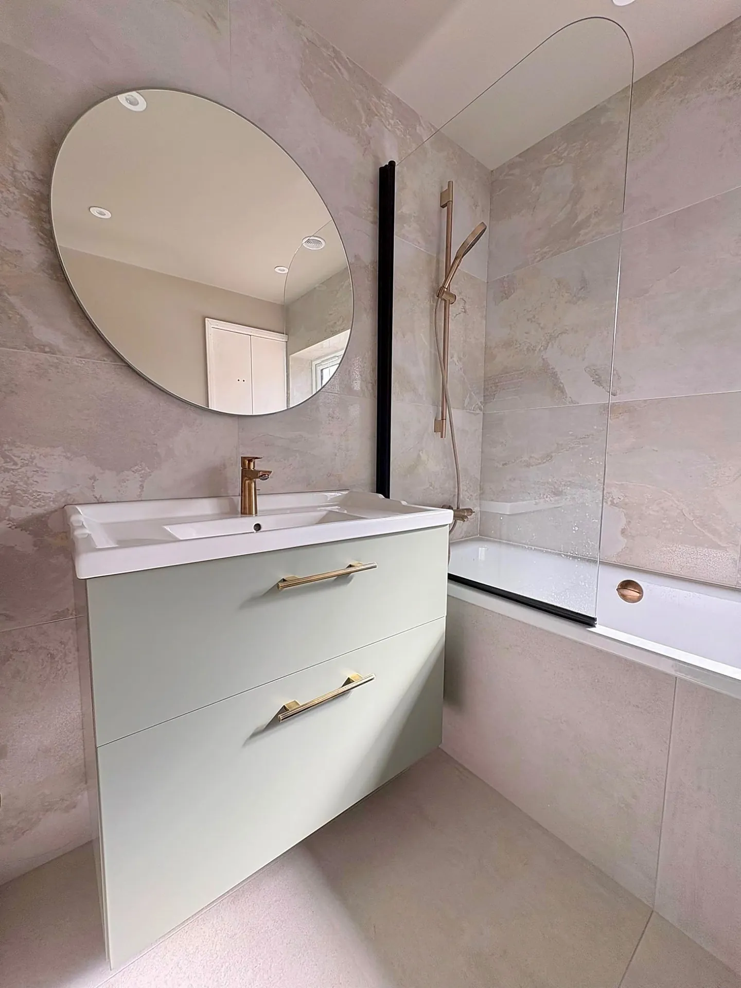 Pale stone bathroom with copper fittings by JM Bathrooms in Haywards Heath